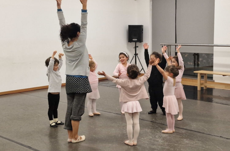 Grupo de crianças a dançar com professora em estúdio